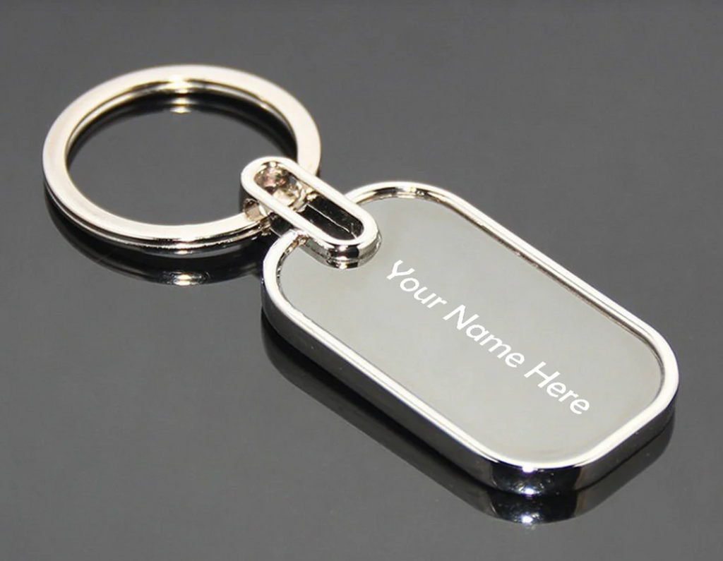 Silver keychain with customizable name tag on a reflective surface